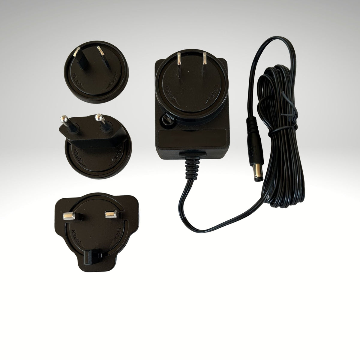 Black power adapter with multiple plug heads on a white background