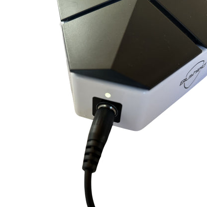 Blushield device with a cable plugged into it on a white background